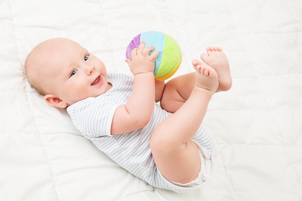 New born baby playing with soft toy