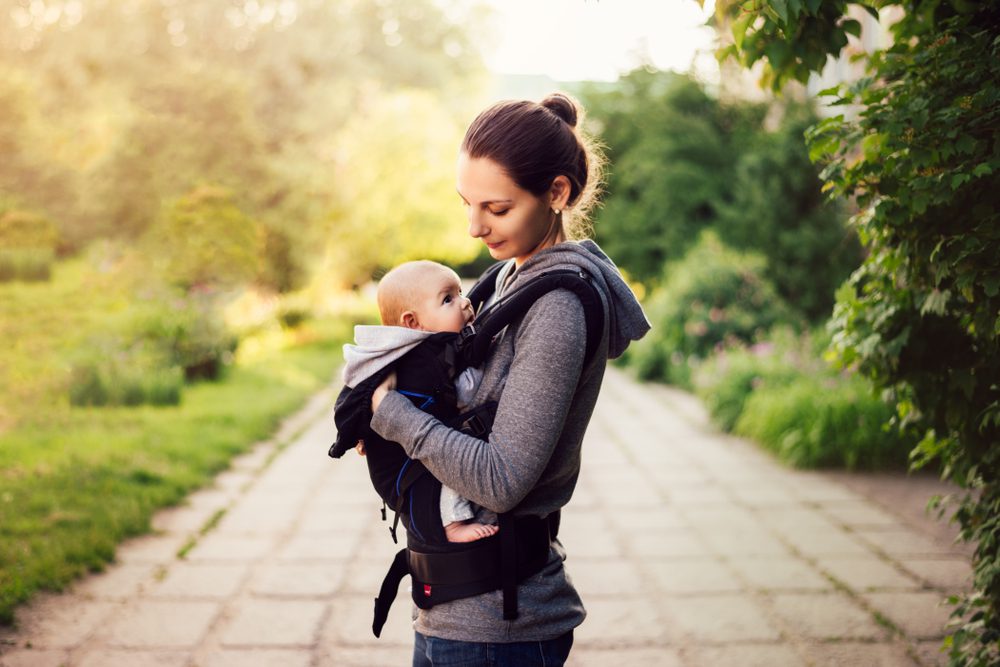 A mother carrying her baby in baby carrier