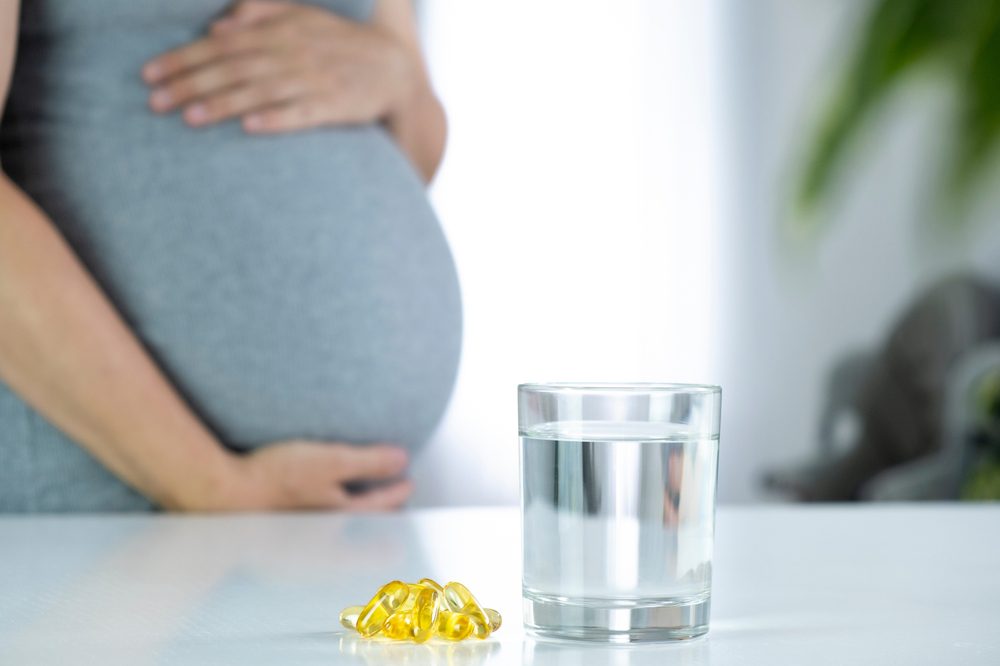 women with omega-3 tablets and glass of water