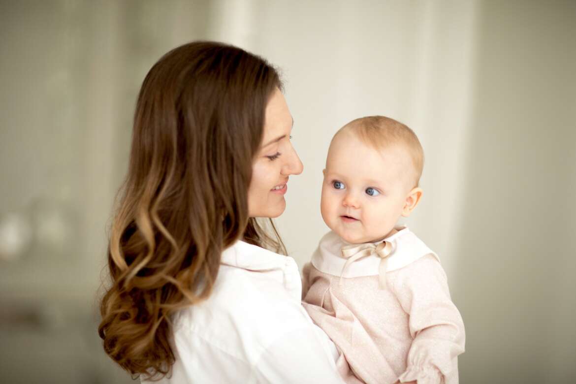 Close-up head shot side view of a mother and her infant daughter.