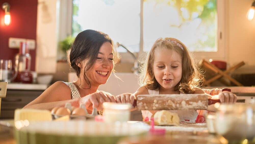 Mother and daughter having quality time together by cooking food to strengthen the bond between them